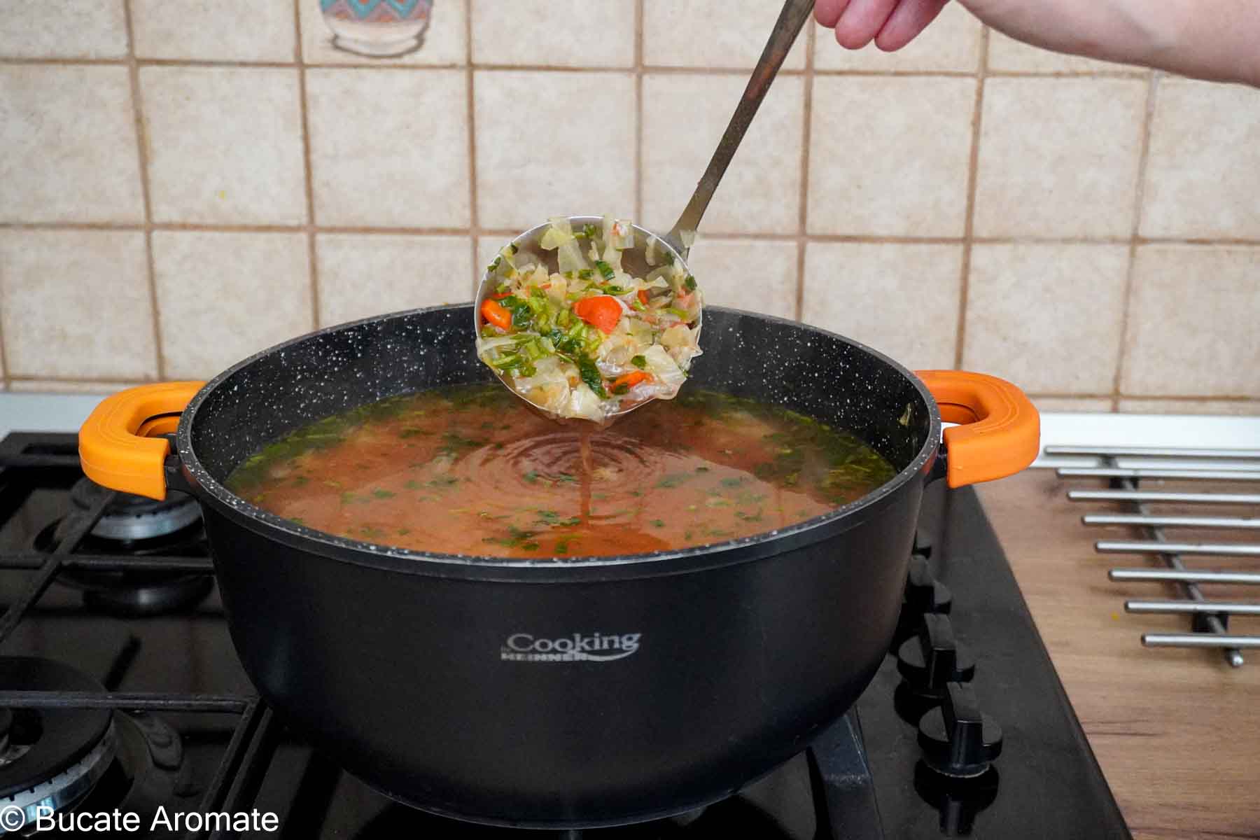 Ciorbă de varză dulce de post cu borș, legume și orez, în oală pe aragaz, rețetă tradițională moldovenească.