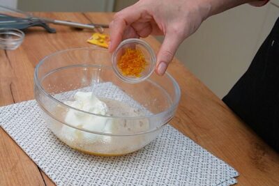 Coajă rasă de portocală adăugată în amestecul cu iaurt pentru gogoși rapide cu praf de copt și mere