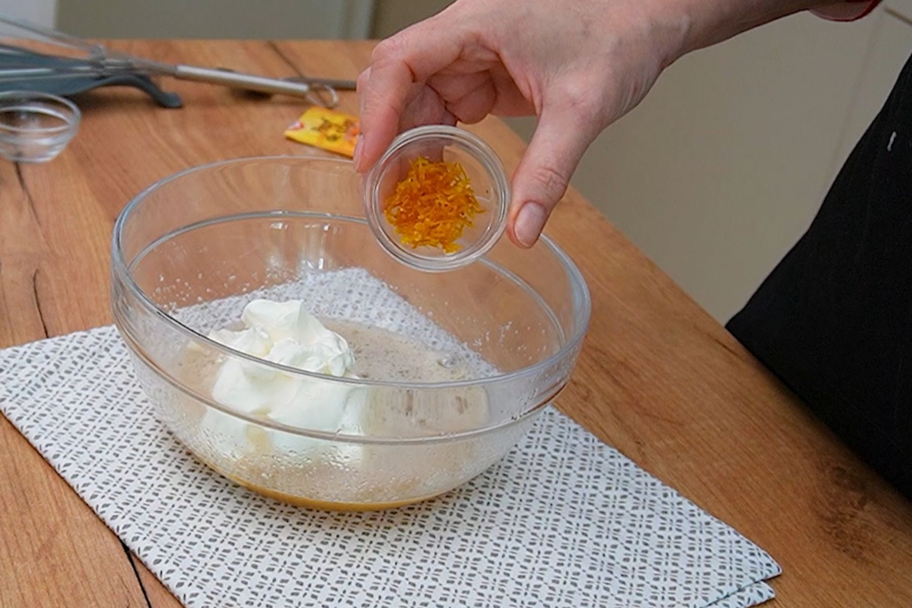 Coajă rasă de portocală adăugată în amestecul cu iaurt pentru gogoși rapide cu praf de copt și mere