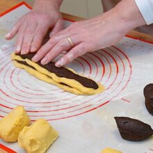 Modelarea biscuiților zebră prin alternarea sulurilor de aluat cu cacao și vanilie