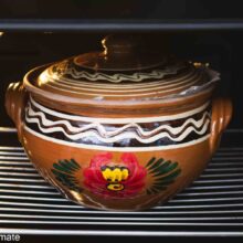 Oală de lut tradițională cu capac, în cuptor, pregătind sarmale de post cu păsat