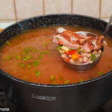 Ciorbă de fasole cu afumătură fiartă în oală, cu boabe de fasole, legume și costiță afumată