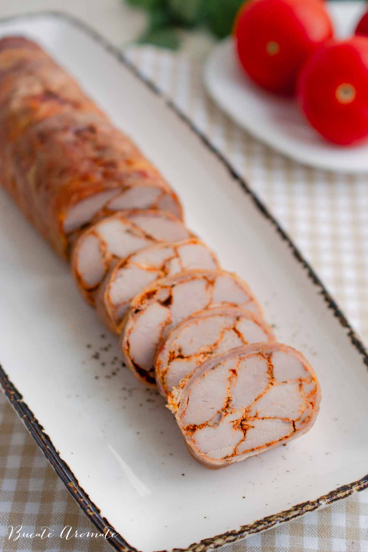 Felii subțiri de ruladă din mușchiuleț de porc învelită în prosciutto, perfectă pentru platou de aperitive