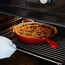 Tigaia cu orez și ciuperci introdusă în cuptor pentru coacere, la finalul rețetei de orez de post cu ciuperci