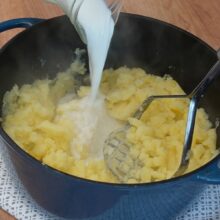 Cartofi fierți zdrobiți cu presă, peste care se adaugă lapte pentru piure cremos