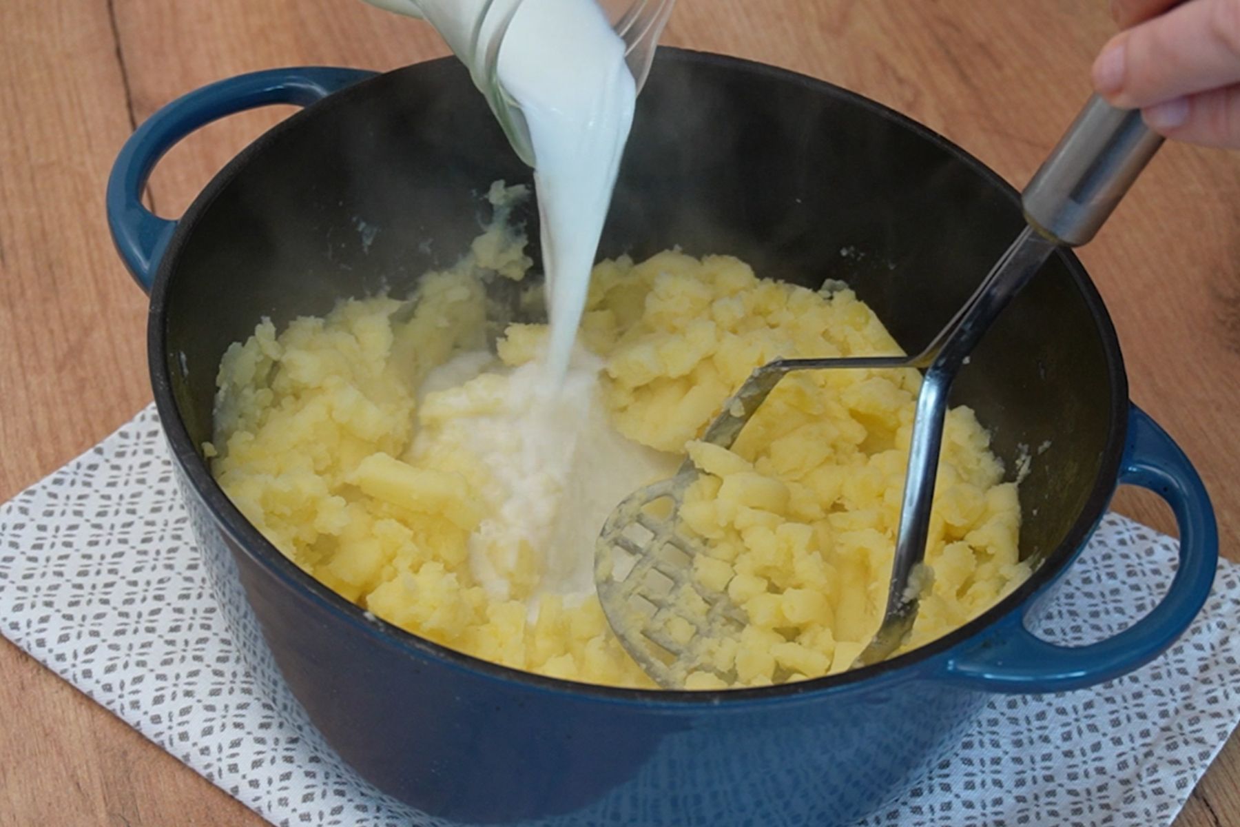 Cartofi fierți zdrobiți cu presă, peste care se adaugă lapte pentru piure cremos