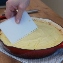 Piure de cartofi întins uniform peste stratul de carne pentru plăcinta ciobanului