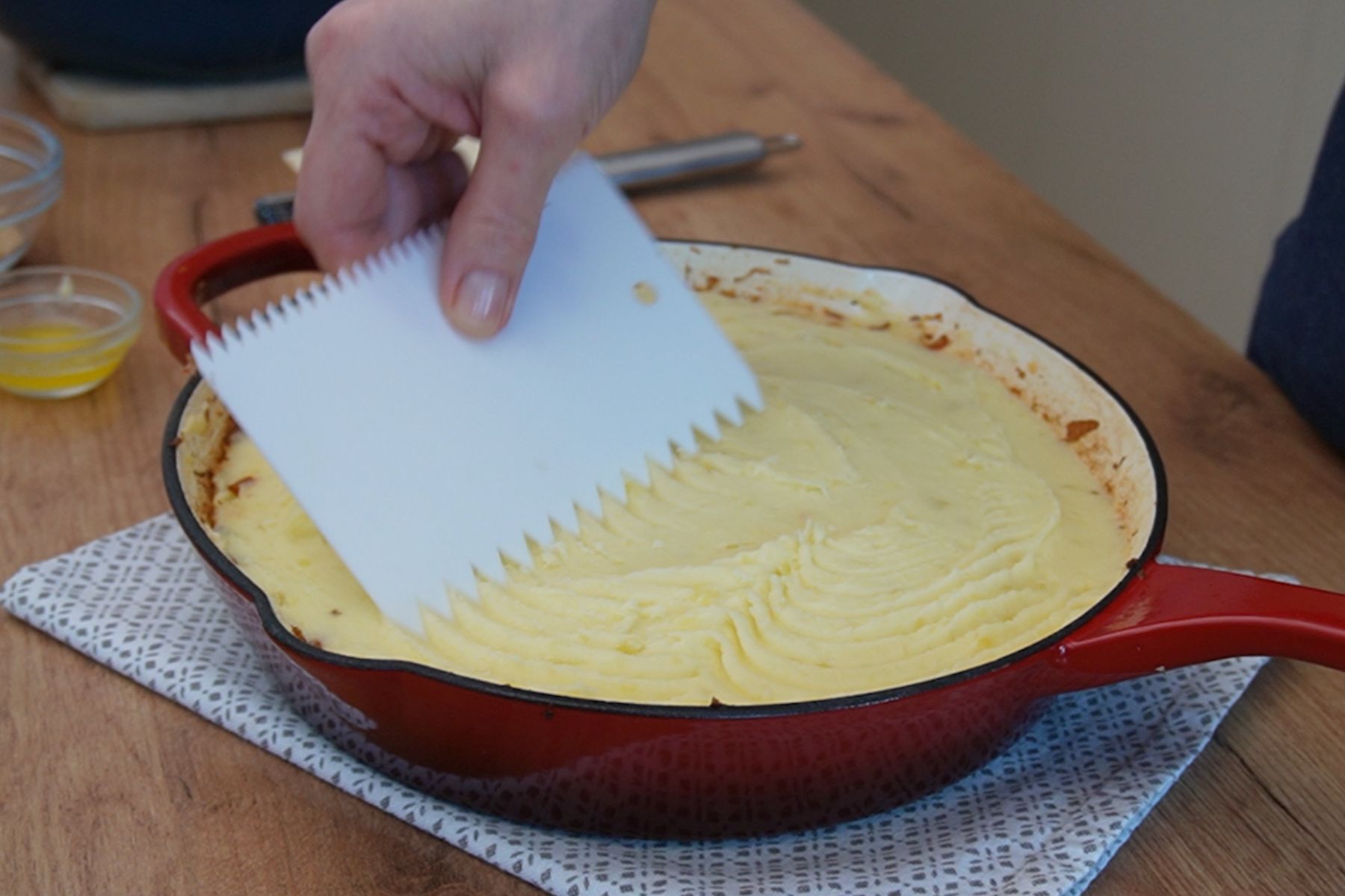 Piure de cartofi întins uniform peste stratul de carne pentru plăcinta ciobanului