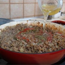 Supă turnată peste carnea tocată cu ceapă și condimente, pentru sosul de carne