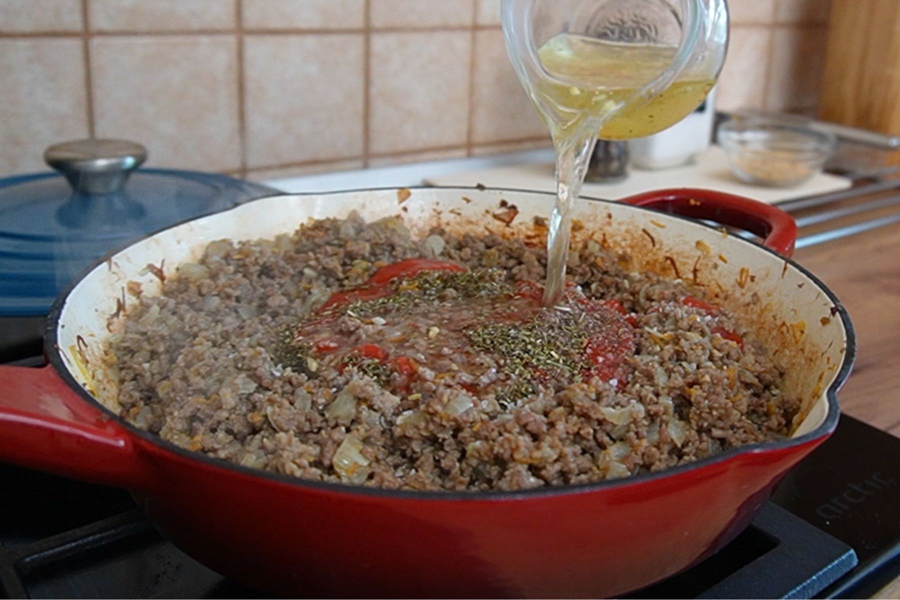 Supă turnată peste carnea tocată cu ceapă și condimente, pentru sosul de carne