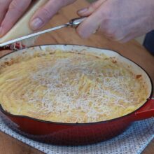 Parmezan ras fin presărat peste piure și pesmet, pentru crustă crocantă