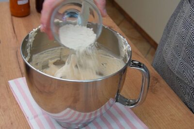 Adăugarea făinii în aluatul simplu pentru blatul alb de la prăjitura Zi și Noapte