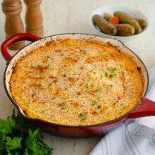 Plăcintă ciobanului la cuptor servită pe farfurie, cu piure cremos și carne suculentă