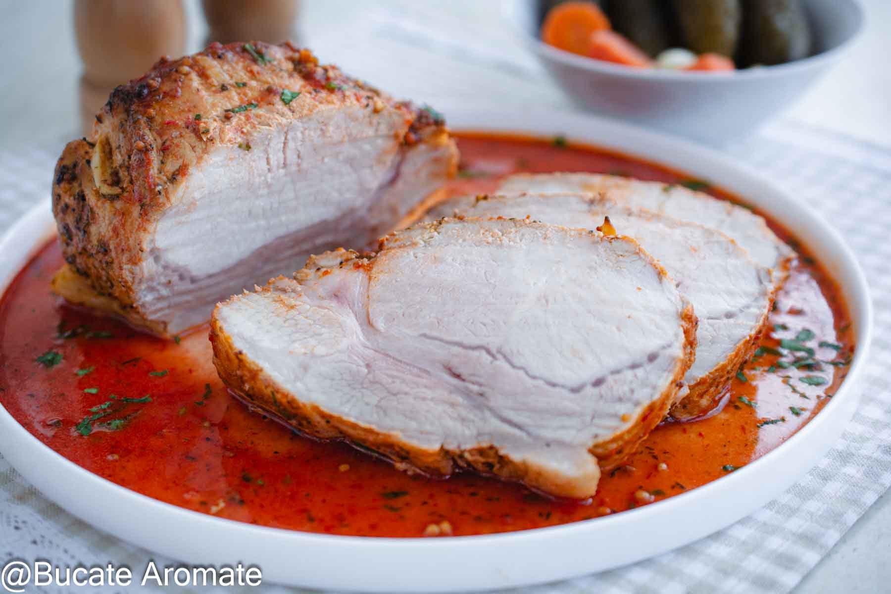 Felii groase de mușchi de porc la cuptor, gătit întreg și servit cu sos roșu