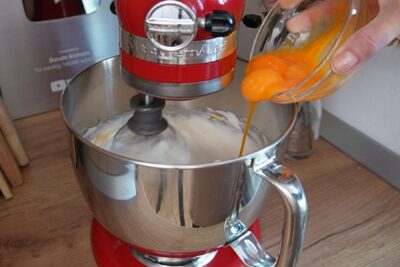 Gălbenușurile se adaugă peste albușurile bătute spumă, pentru a obține compoziția aerată a blatului de pandișpan