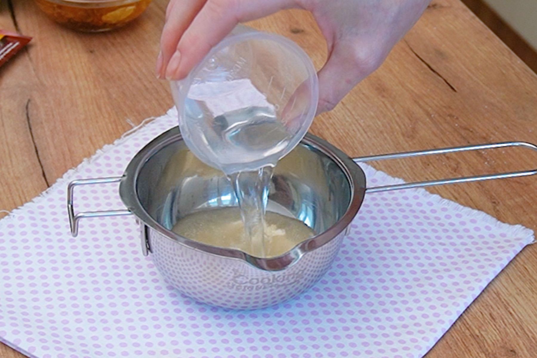 Apa rece se toarnă peste gelatina granule, pentru hidratarea corectă înainte de a fi adăugată în crema Diplomat