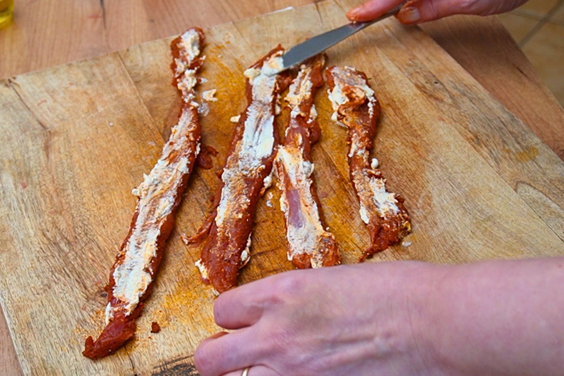 Fâșii de mușchiuleț de porc condimentate și unse cu cremă de brânză pentru rulada mozaic