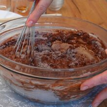 Aluat de post cu cacao amestecat cu telul într-un bol pentru blatul tortului de post cu ciocolată