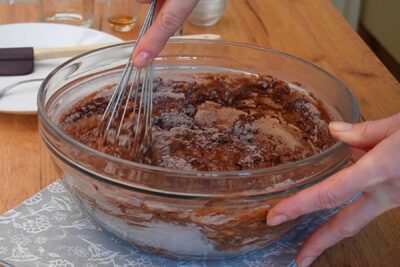 Aluat de post cu cacao amestecat cu telul într-un bol pentru blatul tortului de post cu ciocolată