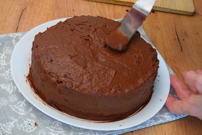 Tort de post cu ciocolată acoperit cu cremă fină de ciocolată înainte de decorare
