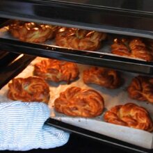 Covrigi polonezi împletiți la copt, așezați câte 6 în fiecare tavă, în cuptorul preîncălzit