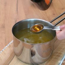 Prepararea siropului pentru covrigi polonezi, într-o crăticioară, cu miere și rom