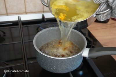 Siropul fierbinte este turnat peste zahărul caramelizat într-o crăticioară, pentru siropul de savarine cu pesmet la tavă.