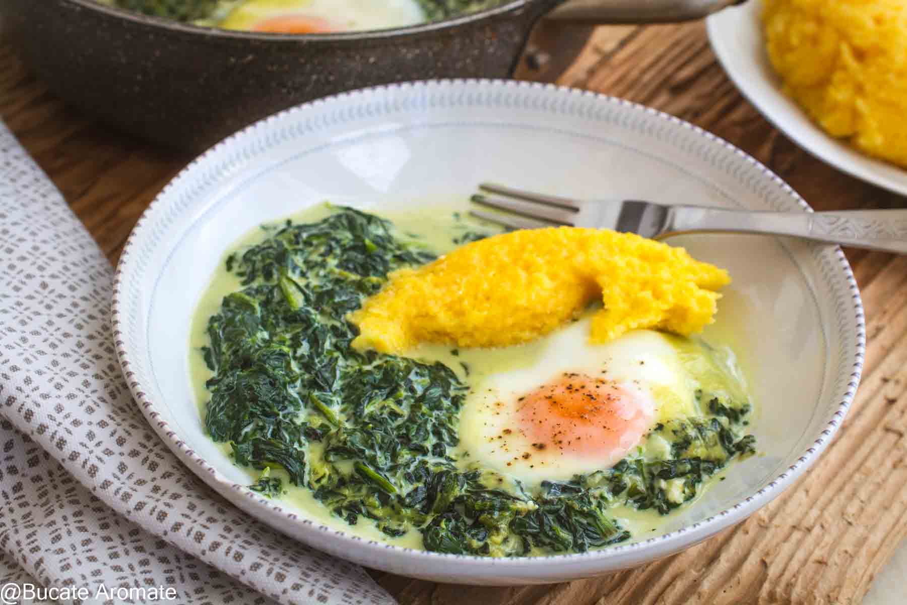 Porție de spanac cremos cu lapte, ou moale și mămăligă, așezată în farfurie pentru servire