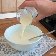 Laptele amestecat cu amidon într-un bol, pregătit pentru spanacul cremos cu ouă