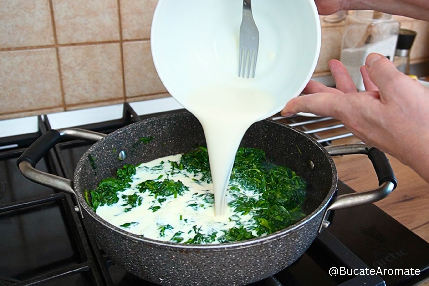 Amestecul de lapte și amidon turnat în tigaie peste spanacul sotat