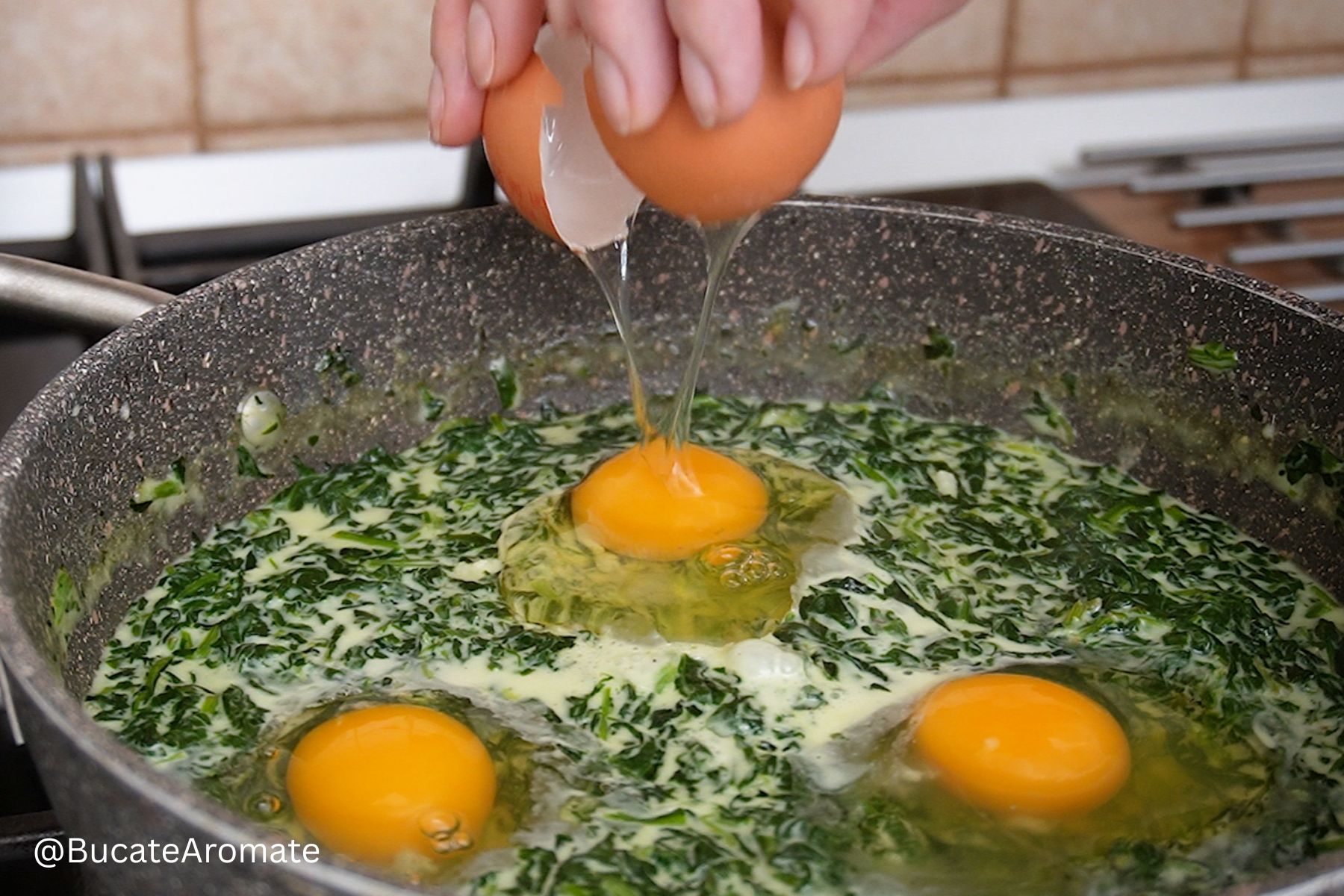 Ouă sparte direct în tigaie peste spanacul cu lapte, înainte de gătirea sub capac