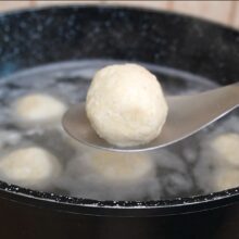 Gălușcă cu brânză de vaci fiartă, scoasă din apă cu o lingură