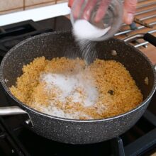 Adăugarea zahărului peste pesmetul rumenit pentru găluște cu căpșuni