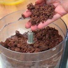 Aluat fraged cu cacao, pregătit la robot, cu textură nisipoasă pentru prăjitura Rudy cu brânză și căpșuni.