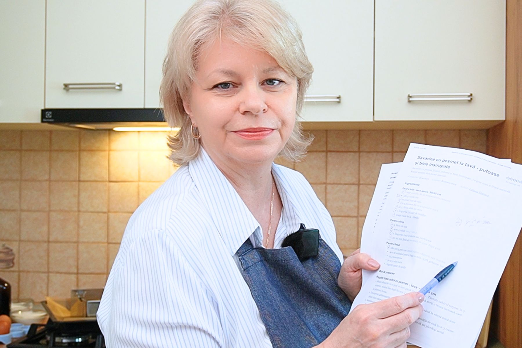 Iuliana Sbîrnea verifică o rețetă tipărită în bucătărie, cu notițe și corecturi pentru Bucate Aromate.