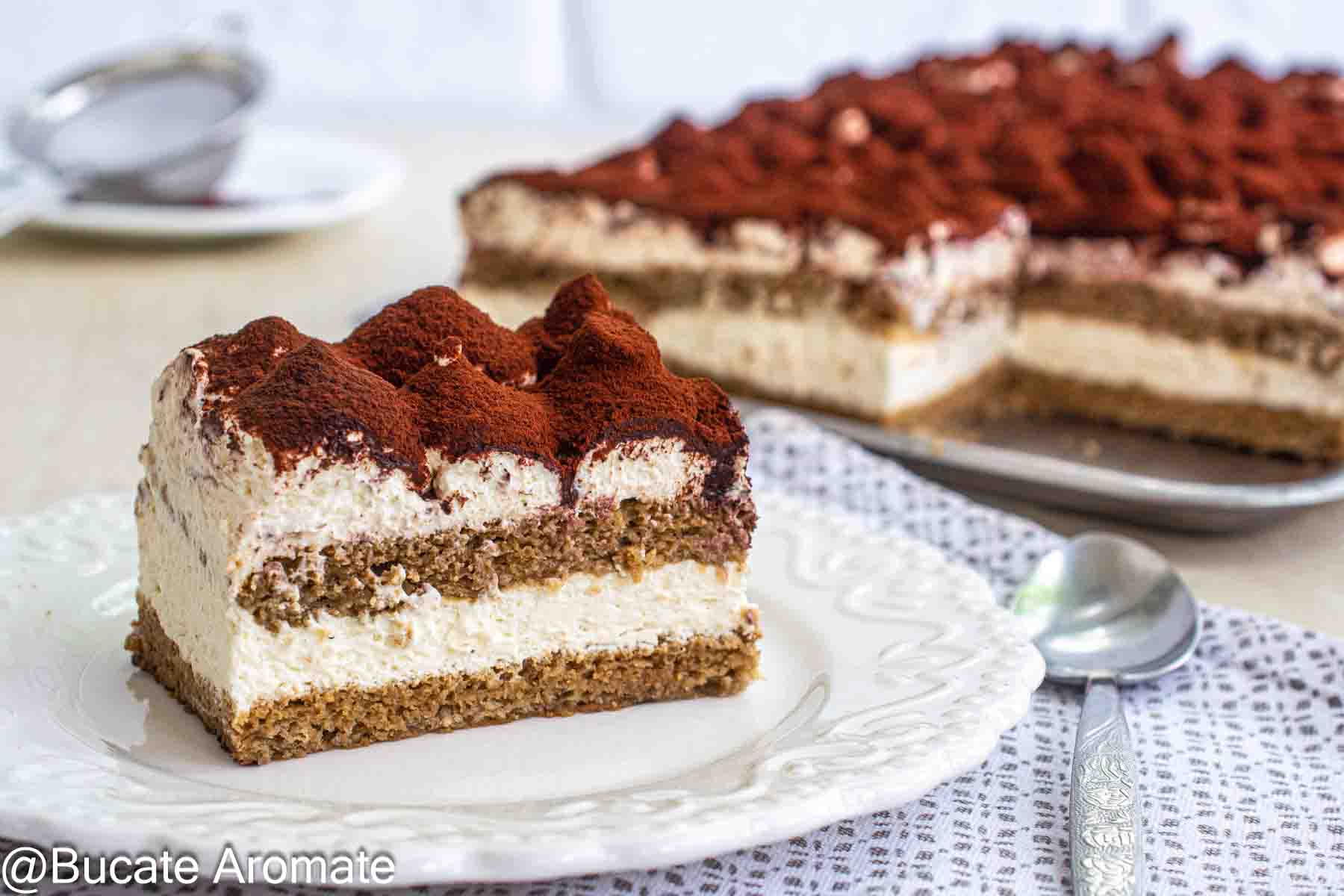 Porție de Tiramisu fără pișcoturi, cu blat pufos de casă, cremă fină de mascarpone și cacao pudrată deasupra