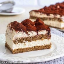 Felie de prăjitură Tiramisu la tavă, cu două straturi de blat însiropat, cremă de mascarpone și decor cu cacao
