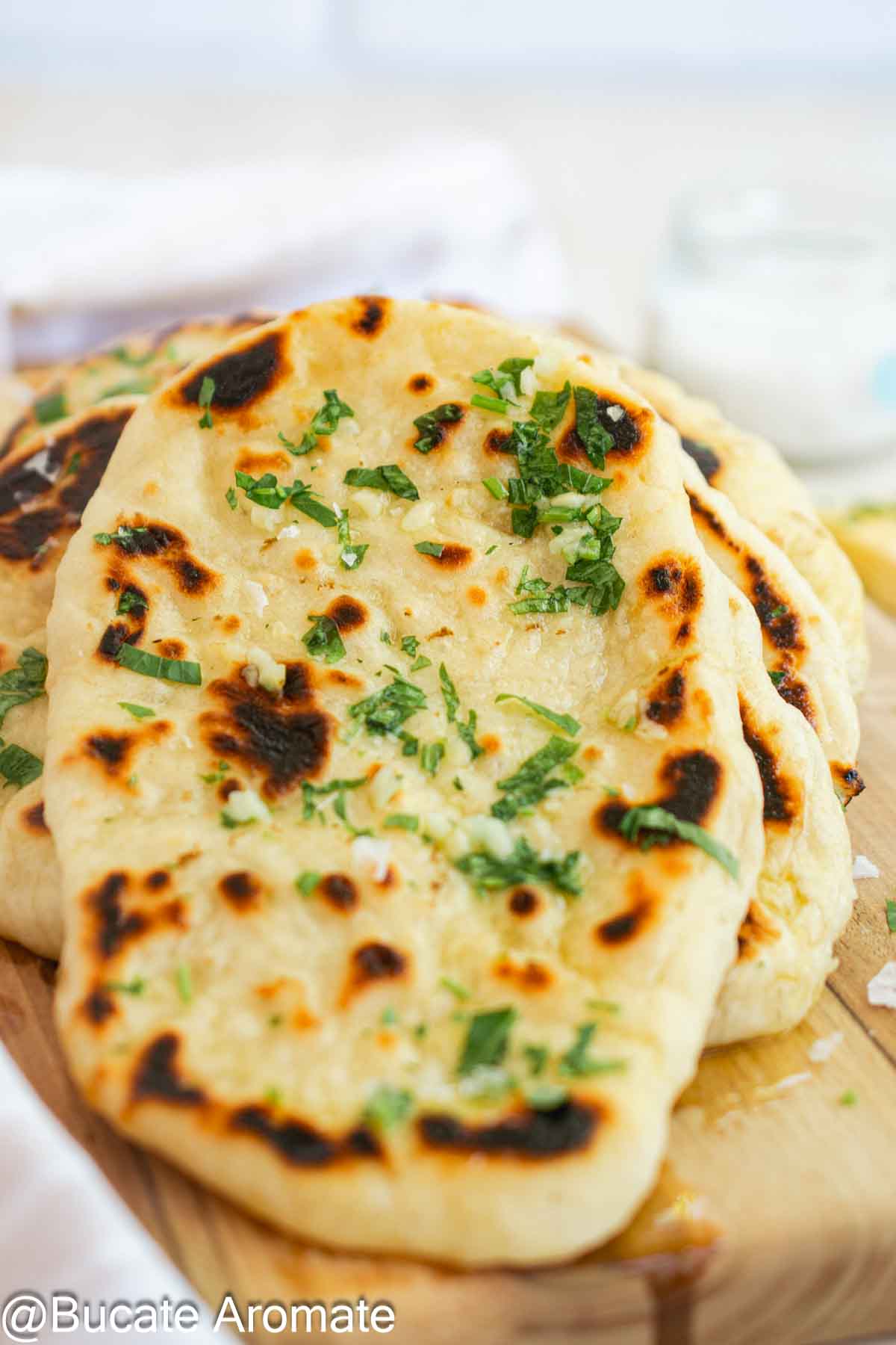 Naan cu drojdie la tigaie, rumenite și unse cu unt aromatizat cu usturoi și pătrunjel verde