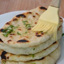 Lipii naan calde unse cu unt, usturoi și pătrunjel după coacere