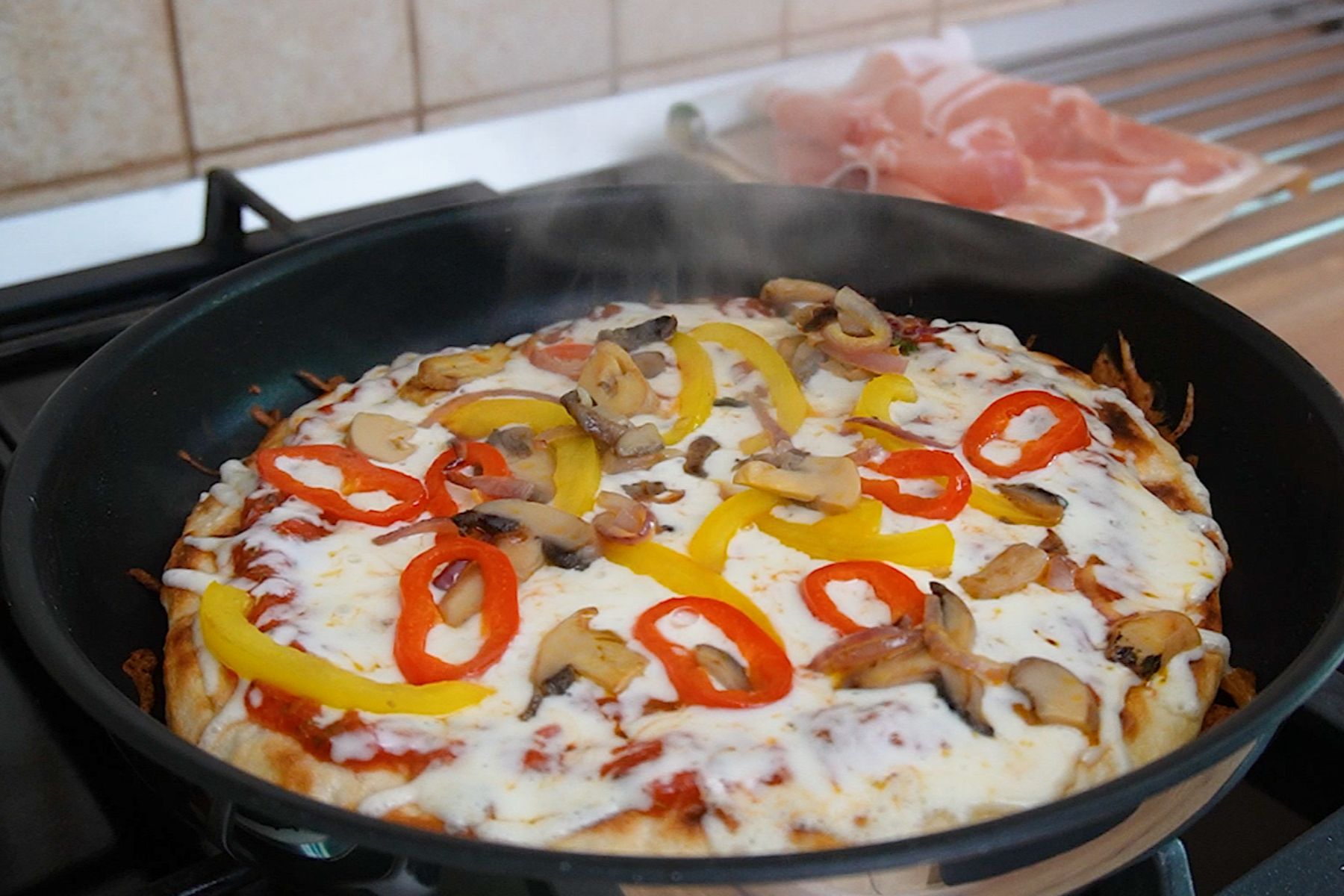 Pizza la tigaie cu cașcaval topit, ardei roșu și galben, ceapă și ciuperci călite.