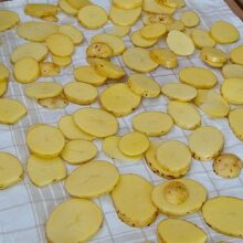 Rondele de cartofi așezate pe prosop curat pentru uscare înainte de coacerea la cuptor