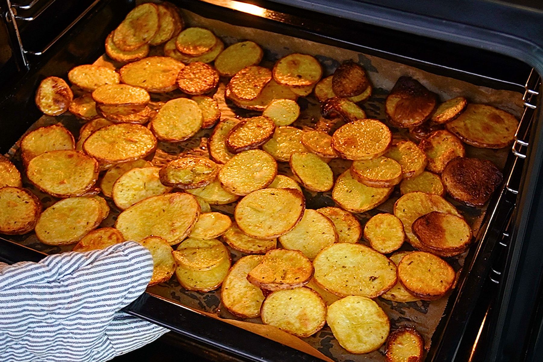 Cartofi rondele rumeniți la cuptor, aurii pe margini și copți pe hârtie de copt