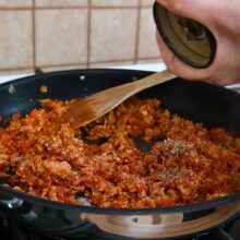 Carne tocată de pui gătită în sos de roșii cu ceapă, usturoi, boia și condimente, amestecată în tigaie.