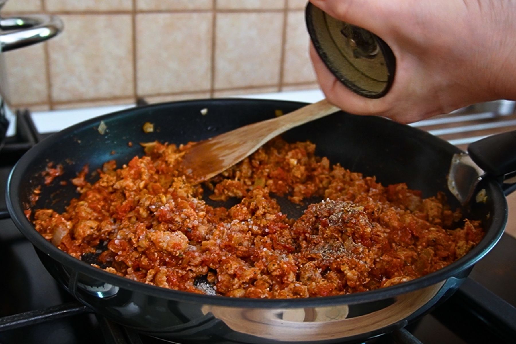 Carne tocată de pui gătită în sos de roșii cu ceapă, usturoi, boia și condimente, amestecată în tigaie.