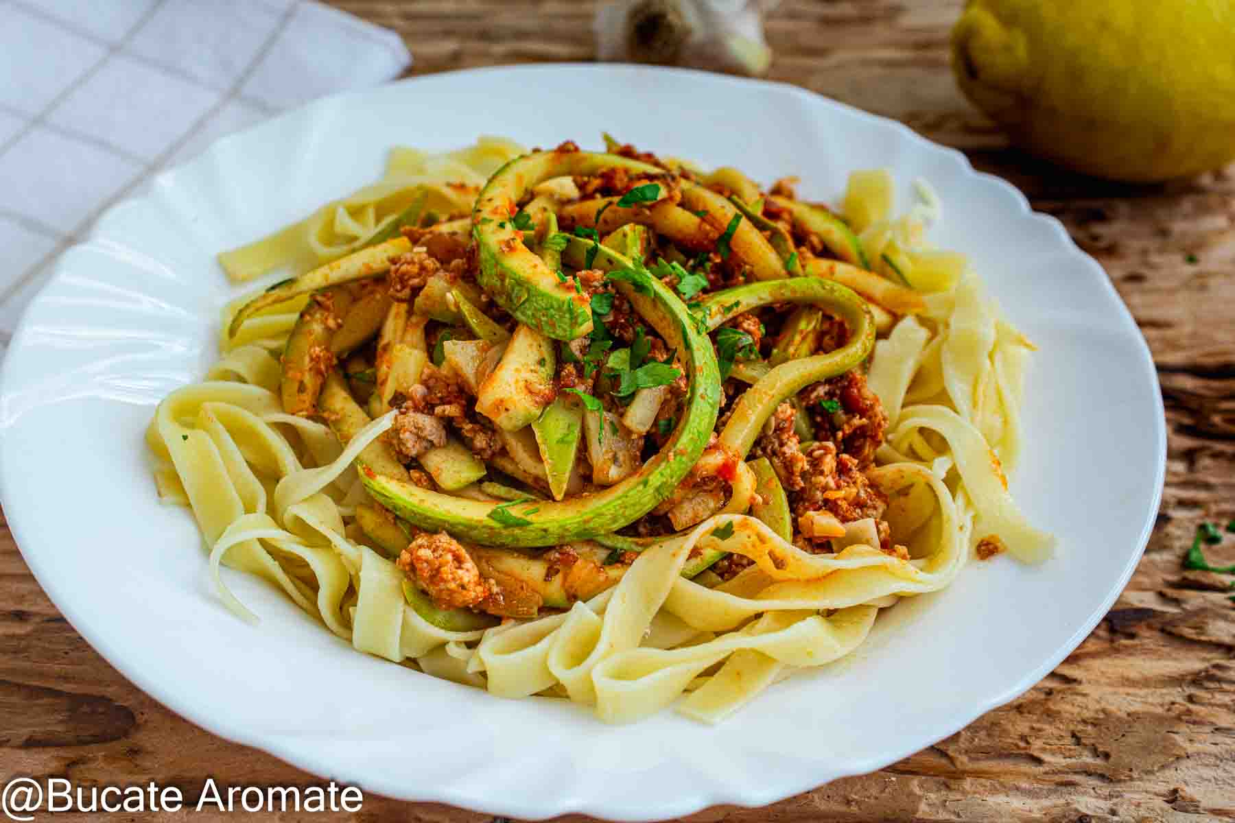 Dovlecei cu carne tocată de pui în sos de roșii, serviți peste paste late, cu pătrunjel proaspăt.