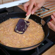 Compoziție de carne tocată de pui și cartofi întinsă uniform în tigaie pentru plăcintă sărată.