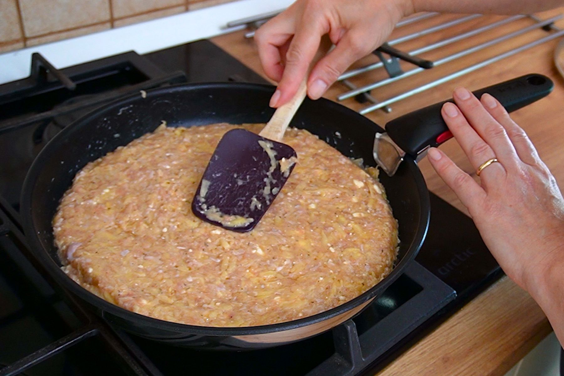Compoziție de carne tocată de pui și cartofi întinsă uniform în tigaie pentru plăcintă sărată.