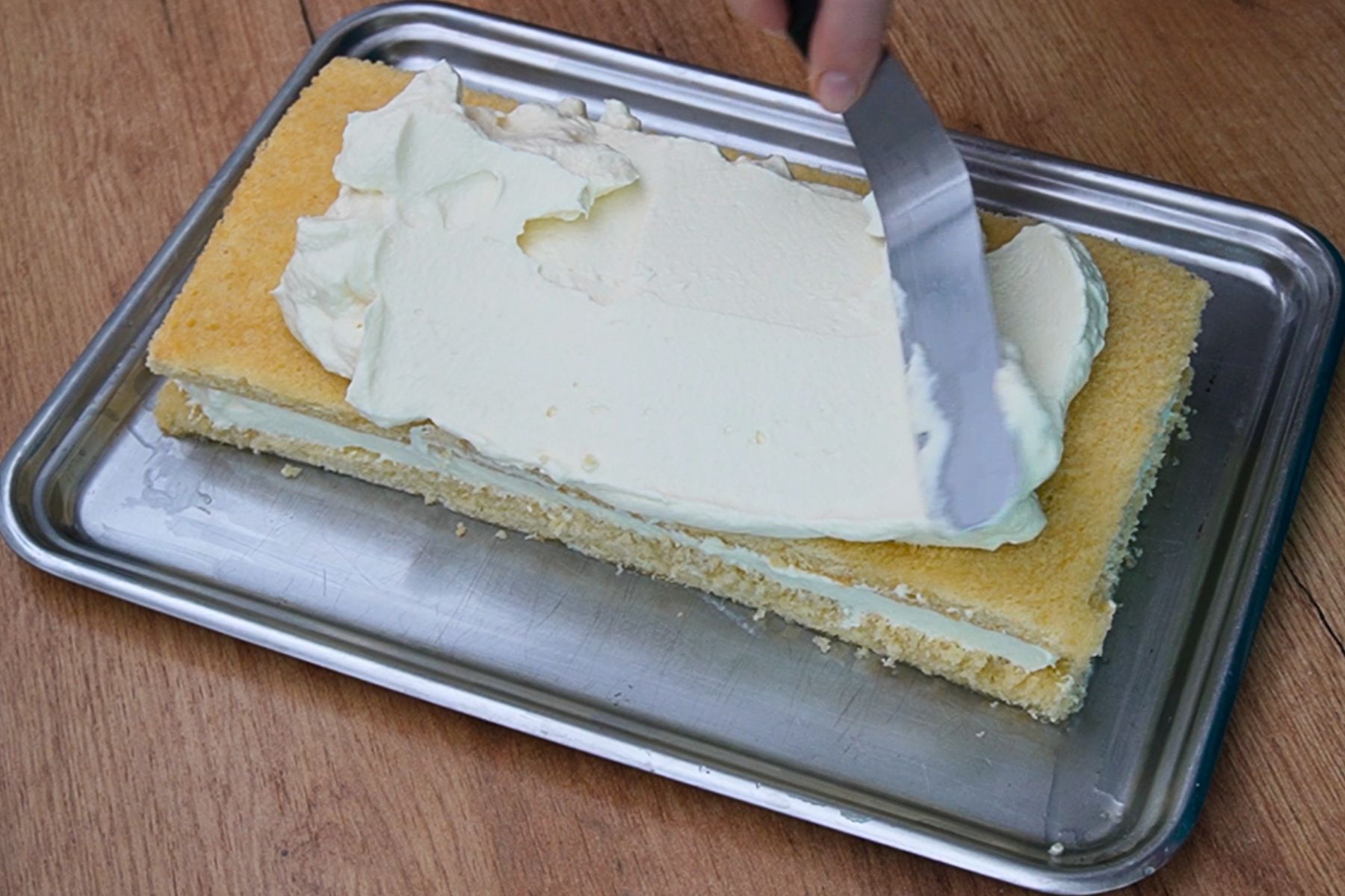 Cremă de frișcă și mascarpone întinsă peste foaia de blat însiropat pentru prăjitura Dunăreana.