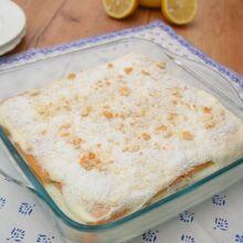 Prăjitură fără coacere cu biscuiți și cremă de lămâie, decorată cu fulgi de cocos și biscuiți mărunțiți