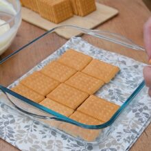 Biscuiți Petit Beurre așezați într-un singur strat în tava pentru prăjitura fără coacere